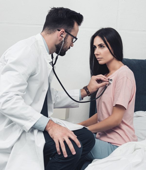 confident young doctor listening breath of female patient